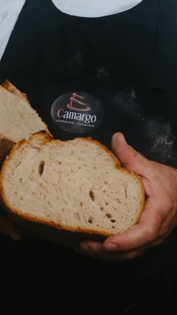 Przekrojony bochenek chleba w dłoniach piekarza